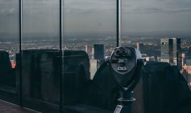 black telescope near glass building during daytime