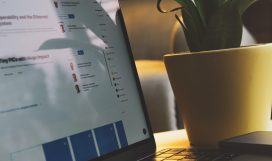 black ipad beside white ceramic mug