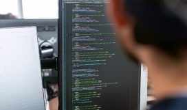 man in black shirt sitting in front of computer monitor
